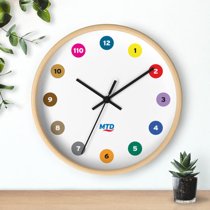 Primary Alt Text Round wall clock featuring colorful MTD route bubbles arranged as hour markers on a white clock face with the MTD logo in the center.
