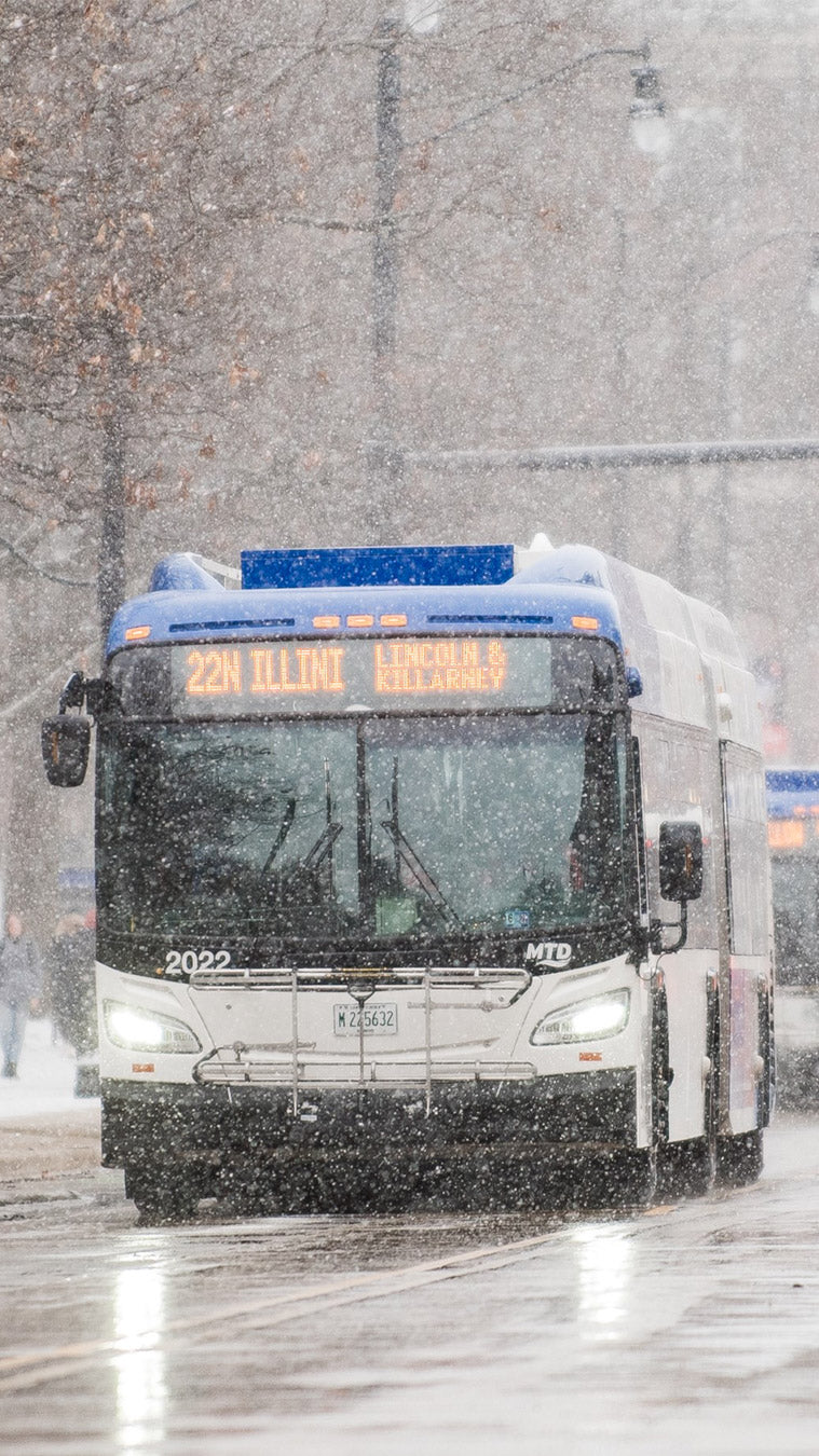 An MTD bus driving through heavy, falling snow.