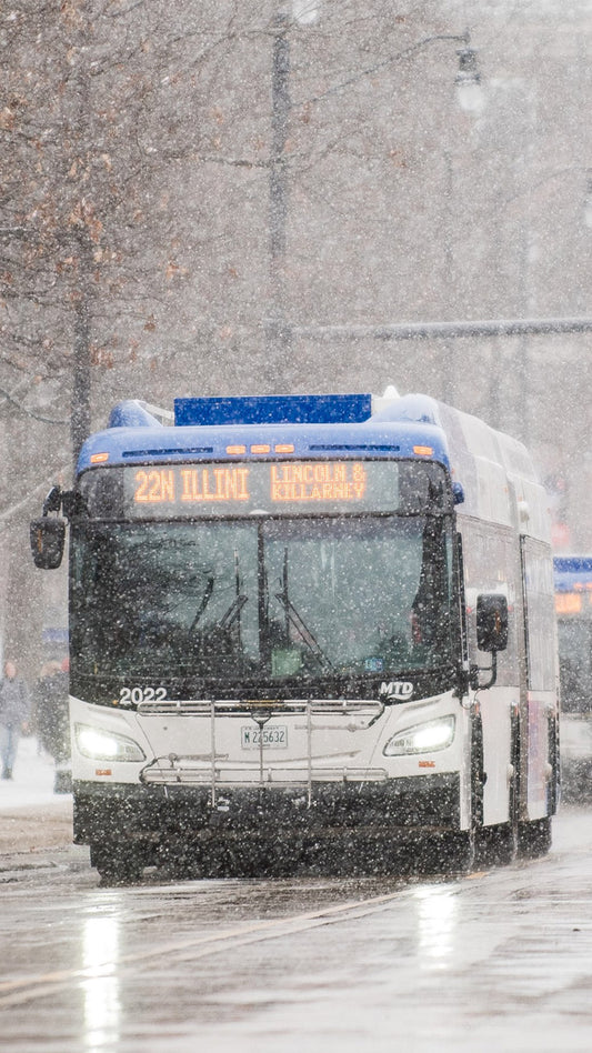An MTD bus driving through heavy, falling snow.