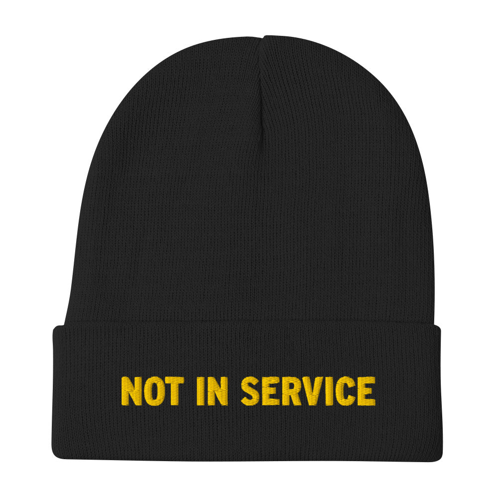 A black beanie with “Not In Service” embroidered on the front in yellow thread. 
