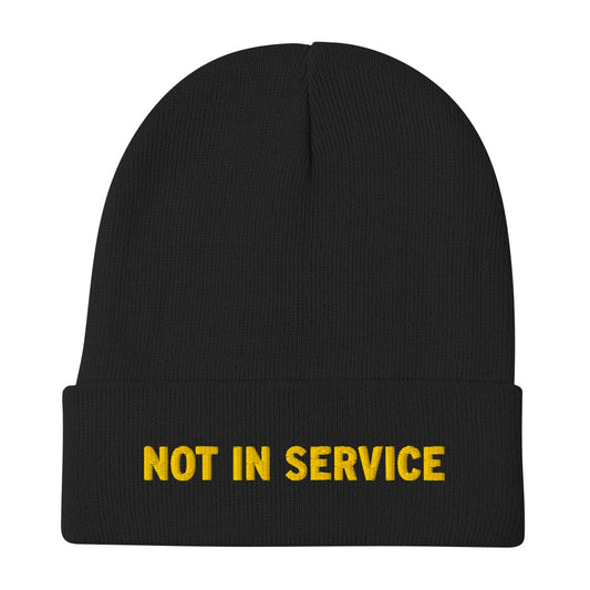 A black beanie with “Not In Service” embroidered on the front in yellow thread. 