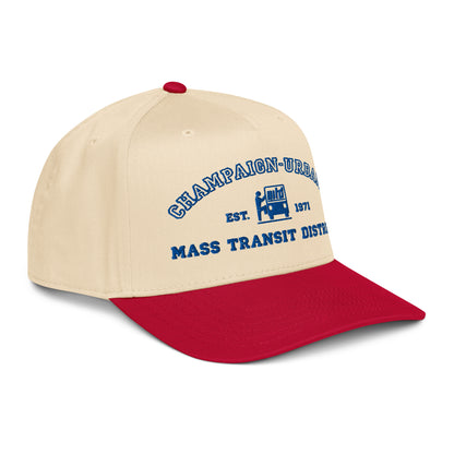 Side view of a tan snapback hat featuring a throwback MTD logo stitched in blue with a red visor.